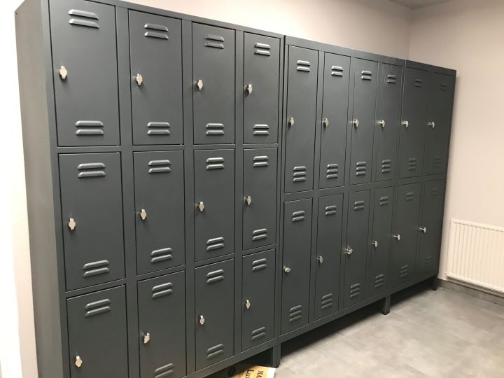 Gråe omklædningsskabe til fitnesscenter med mange låger og låse til opbevaring af tøj og værdigenstande